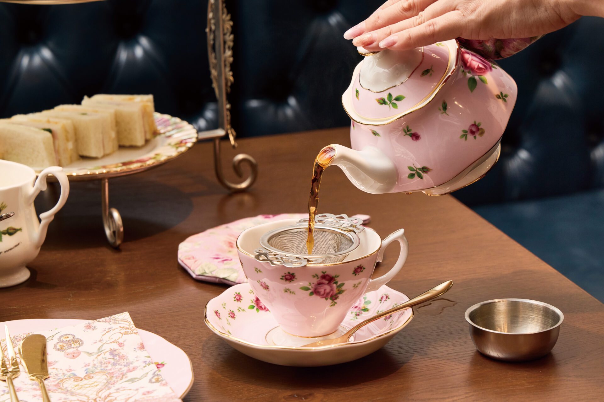 ティーポットから紅茶をカップに注ぐ様子